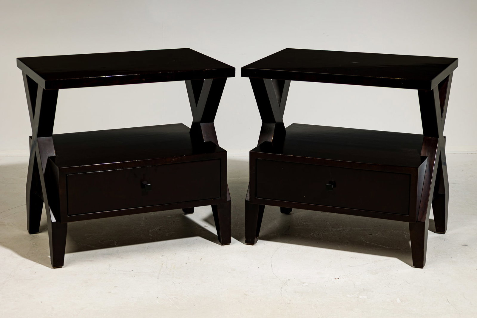Knowlton Brothers, pair contemporary bedside tables: 21st c., USA, black lacquered wood, the square top raised on x-shaped frame, flanking a lower storage drawer, maker's label on inside drawer, 28" h x 28" w x 20" d Provena