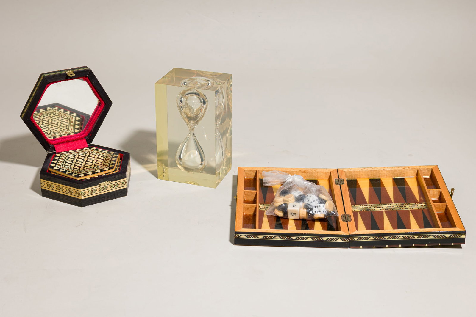 (3) modern tabletop items, inc. Pierre Giraudon hourglass: 20th c. tabletop group includes Pierre Giraudon, 1959, lucite hour glass, unmarked, 6" h x 3.5" w x 3.5" d; Spanish Moorish hand-made inlaid wood and bone box, opens to a mixed woo