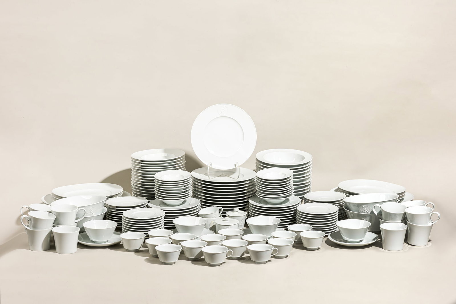 KPM Arcadia, partial service for 20: Introduced 1938, Germany, designed by Trude Petri and Siegmund Schutz, white porcelain with neoclassical relief medallion decoration, including (15) dinner plates, 10.5"dia, (19) soup bowls, 9&qu