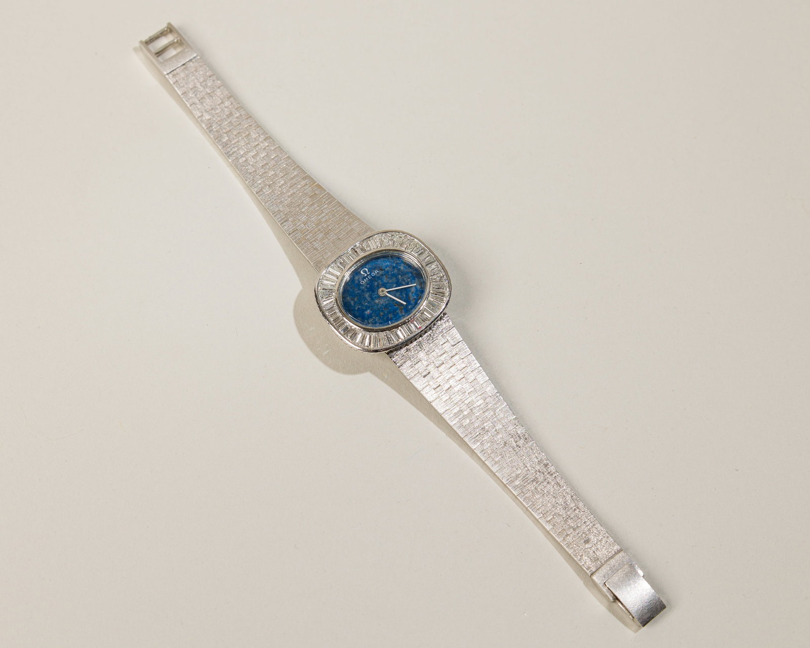 Omega Ladies` Watch In 18K White Gold: Type: Omega C `1970s Dial: Lapis stone dial with diamonds Case Material: 18K white gold Case Dimensions: 25 mm wide x 23 mm top-to-bottom Bracelet Material: Integrated bark finished bracelet in 18K wh