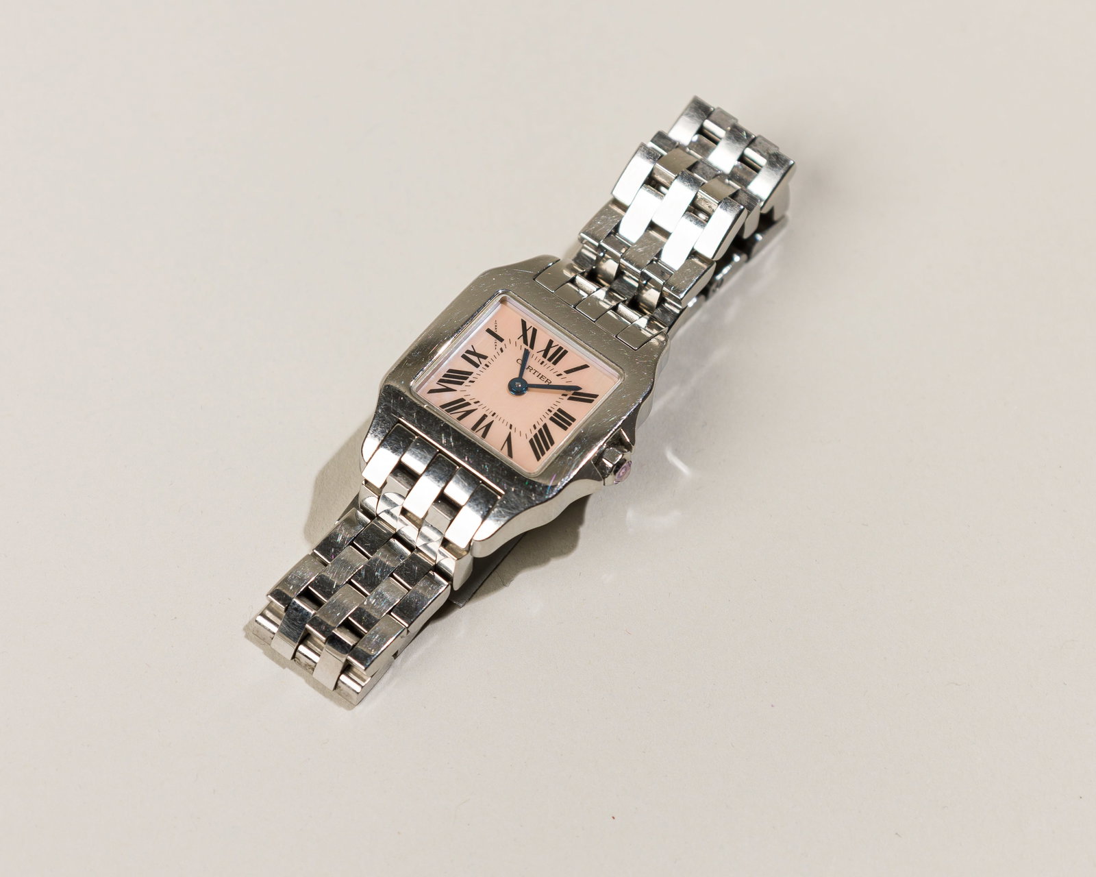 Cartier Santos Demoiselle In Steel With Mother-of-Pearl Dial: Type: Cartier,C`2000s Case Material: Stainless steel Dial: Pink mother-of-pearl dial with printed Roman numerals Case Dimensions: 20 mm wide x 30 mm lug-to-lug Serial Number: 7073354LX Reference Numbe