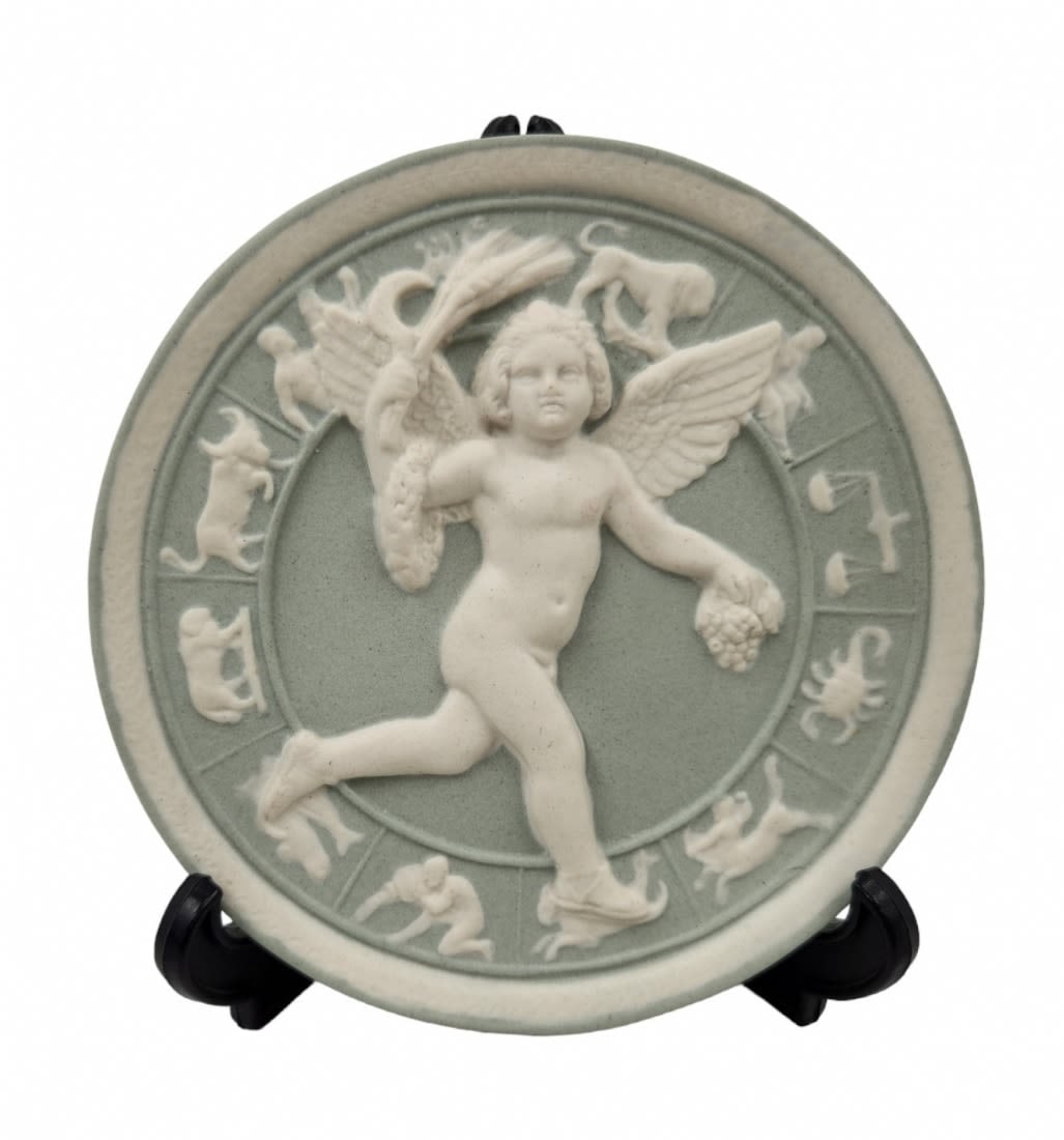 A decorative vessel made of bisque, decorated with the figure of Bacchus and the zodiac: A decorative vessel made of bisque, decorated with the image of Bacchus surrounded by zodiac symbols, partially painted and signed, diameter: 12 cm.