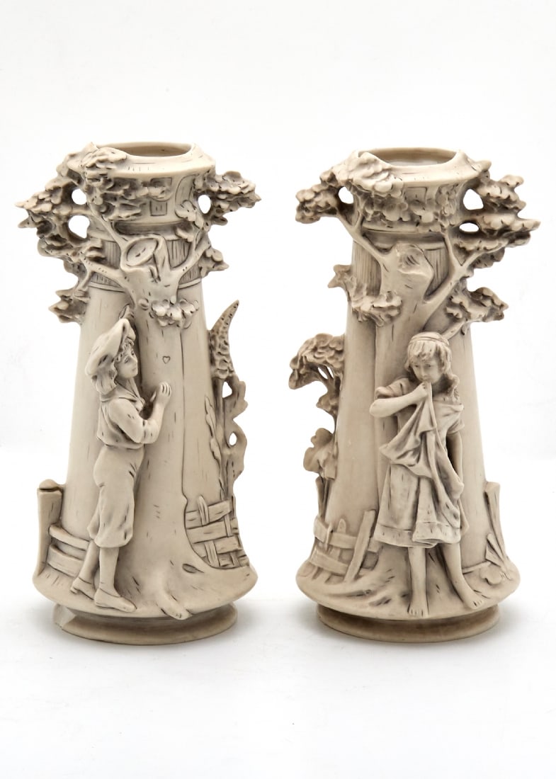 Pair of Czech Art Nouveau Vases, Manufactured by 'Royal Dux': Pair of Czech Art Nouveau Vases, Manufactured by 'Royal Dux', decorated with reliefs of a girl and boy under trees and signed Circa 1900 Height: 26 cm Width: 14 cm One vase has a defect at t