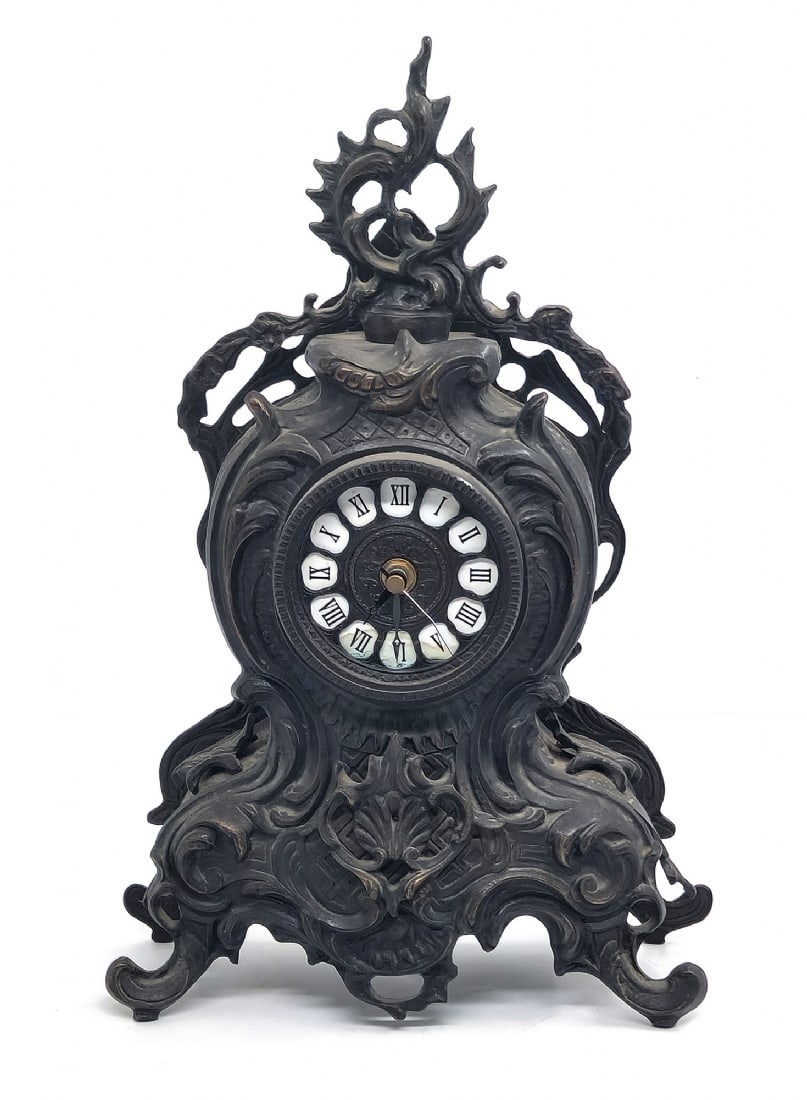 Decorative Antique-Style Table Clock Made of Decorated Metal: Decorative Antique-Style Table Clock Made of Decorated Metal, dial with Roman numerals and quartz mechanism Working condition not tested Height: approx. 41 cm Notice: We are located in Israel and prov