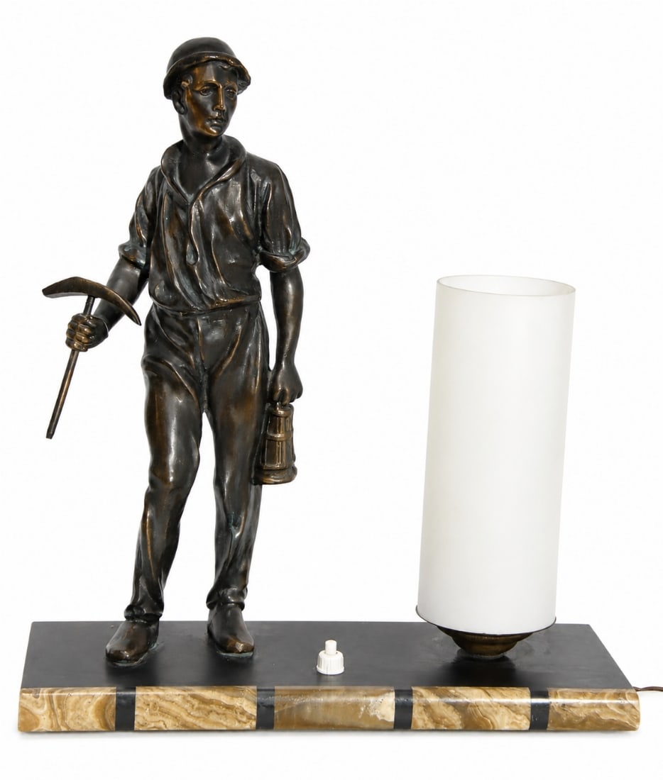 A Spelter Miner Figural Table Lamp with a Cylindrical Glass Shade: A Spelter Miner Figural Table Lamp with a Cylindrical Glass Shade, in working order. Dimensions: 33X29X11 cm. Notice: We are located in Israel and provide full packing and shipping service. You can as