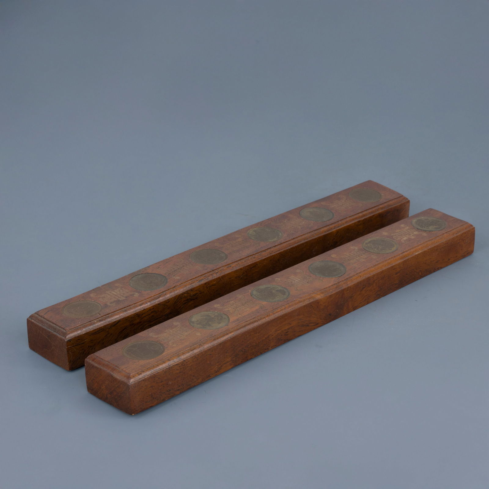 Coppia di ferma disegni, Cina, inizio del XX secolo: Coppia di ferma disegni con decoro di monete raffiguranti diverse figure animali Legno di Huali Cina, inizio del XX secolo 30 x 30,5 cm A pair of paperweights decorated with coins depicting various an