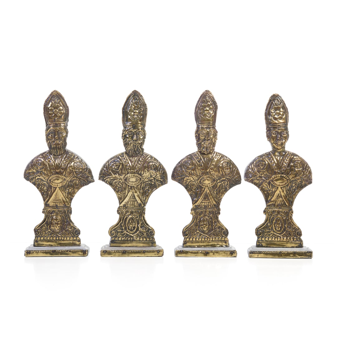 Quattro vescovi, Lombardia, XIX secolo: Quattro vescovi Metallo sbalzato fissato su supporto di legno Lombardia, XIX secolo 44 x 19 cm Four bishops Repoussé metal mounted on a wooden base Lombardy, 19th century 44 x 19 cm