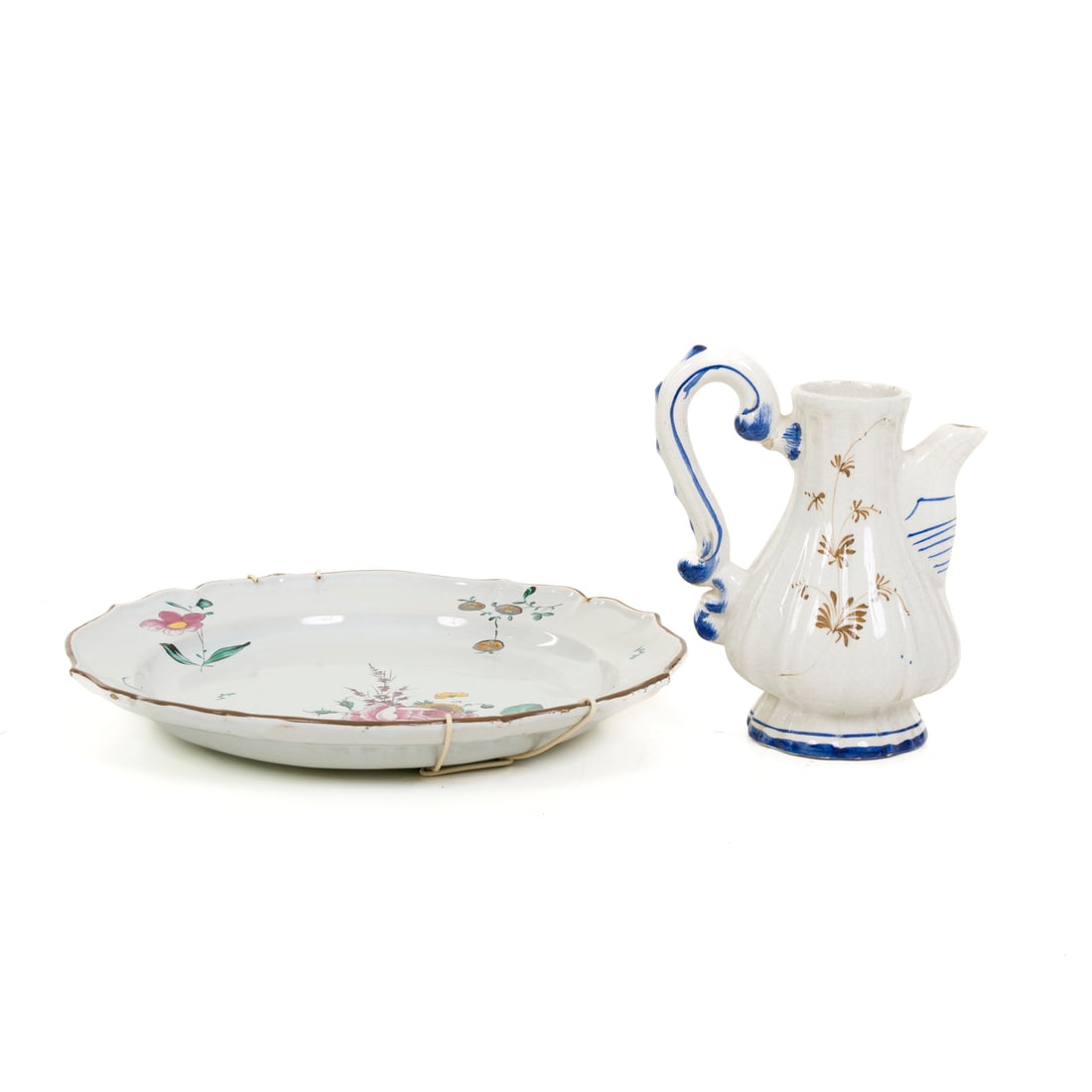 Manifattura Fink e di Bassano, XVIII e inizio XX secolo: Manifattura Fink Piatto Maiolica dipinta Bologna, XVIII secolo d 31 cm Firmato F L sul fondo Manifattura di Bassano Versatoio Ceramica dipinta Bassano, inizio del XX secolo h 18 cm Iscrizione BASSANO 