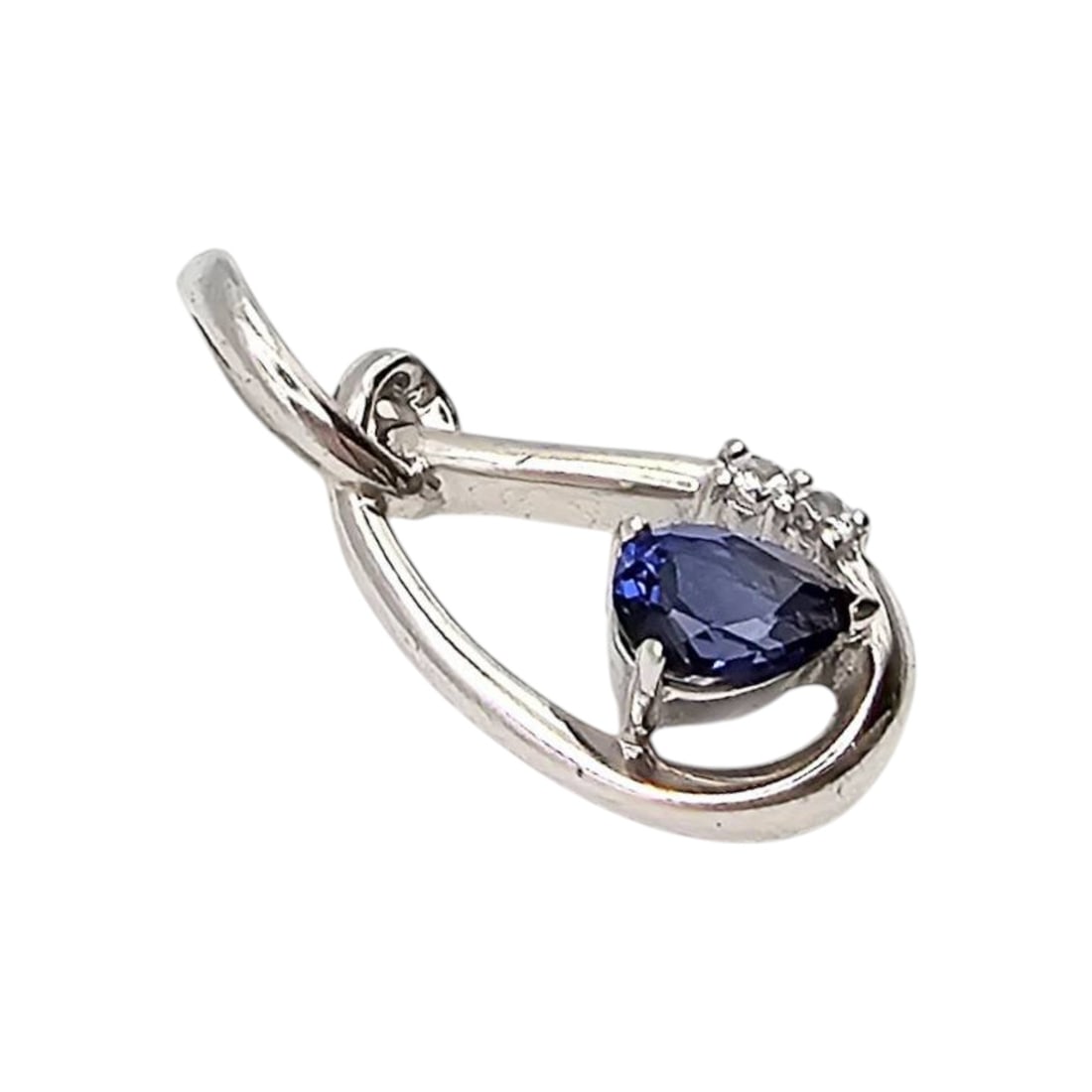 Signed Sapphire and White Topaz Pendant, 2.9 G: Sterling silver pendant featuring a pear-cut sapphire stone enhanced by white topaz accents. Weighing 2.9 grams, the pendant exhibits a graceful loop design. Includes a signature, but the maker's name