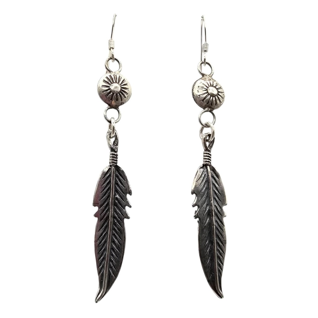 Navajo Sterling Feather Drop Earrings, 4g: Navajo-made drop earrings crafted from sterling silver featuring feather designs. Each earring is approximately 4 grams in weight and includes stamped accents near the hooks. The feather design highli