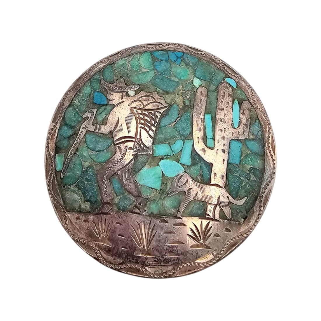 Mexican Sterling and Crushed Turquoise Man and Cactus Brooch/Pendant: Sterling silver brooch/pendant from Mexico featuring a man and cactus design inlaid with crushed turquoise. ' ', 'Mexico', and other markings on the back. Dual functionality as both brooch and pendant