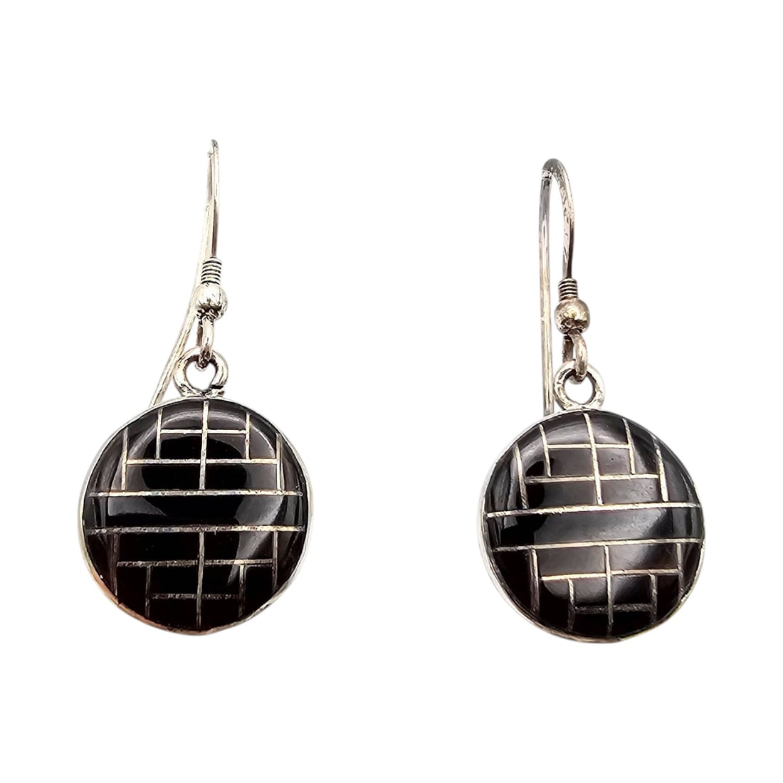 Native Onyx Inlay Drop Sterling Earrings: Elegant drop earrings featuring Native onyx inlays set in sterling silver. The circular onyx panels display a grid-like inlay design. Each earring is marked “STERLING” on the back. The pair we