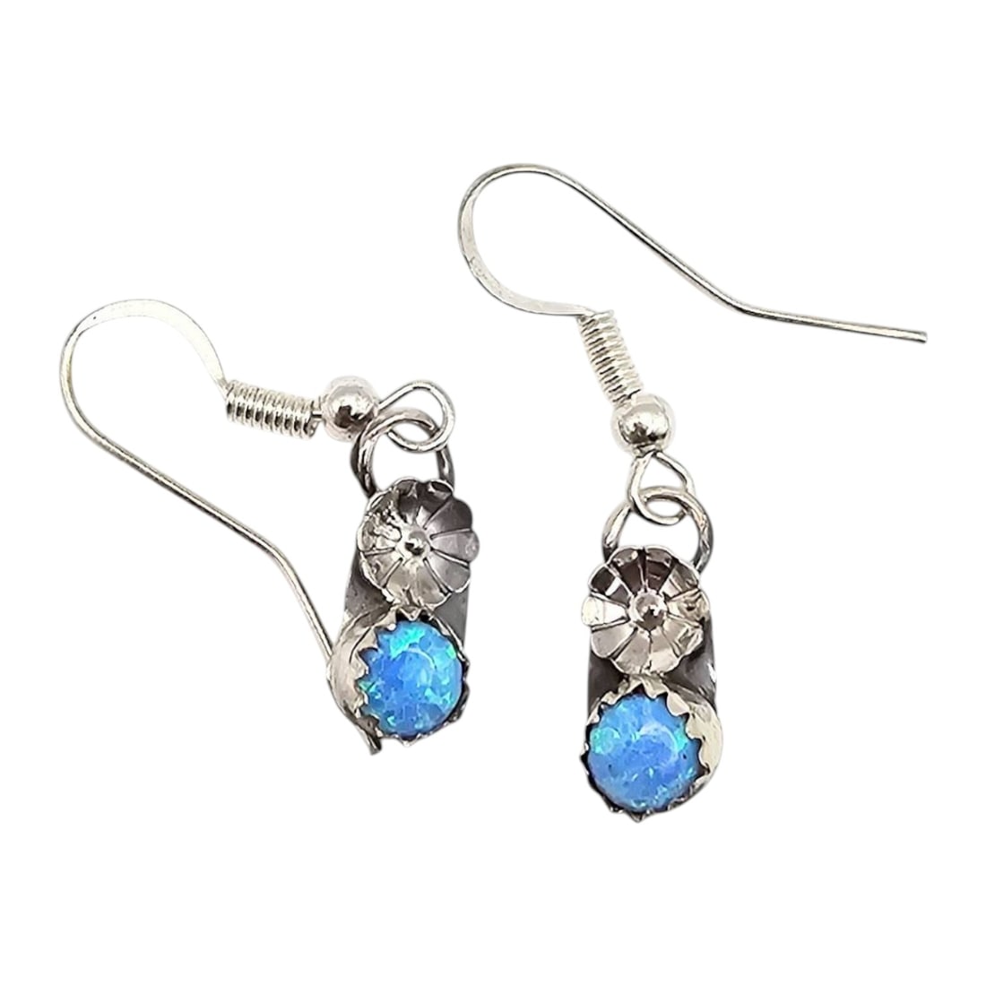 Janice Spencer Navajo Handmade Sterling Silver Opal Earrings: Janice Spencer Navajo handmade sterling silver earrings featuring synthetic opal stones. The earrings weigh 1.6 grams in total. Each earring is adorned with a floral motif crafted in sterling silver.