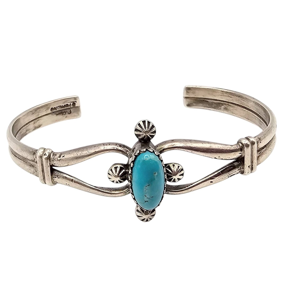Danny Clark Navajo Turquoise Sterling Silver Cuff Bracelet: A handcrafted Navajo cuff bracelet by Danny Clark, made of sterling silver and featuring an oval turquoise stone at the center. The piece is accented with traditional Native American designs, includin