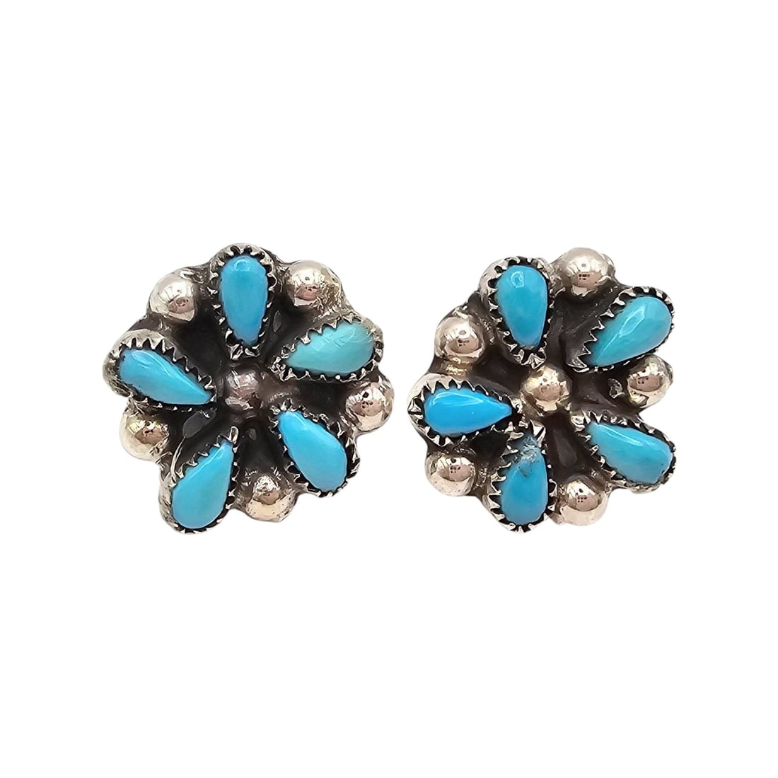 Navajo Turquoise Sterling Silver Flower Earrings: Navajo artisan-crafted flower-shaped earrings made of sterling silver and turquoise inlay, showcasing Turquoise stones in a petal arrangement. Each earring features a secure clip-on backing and weighs