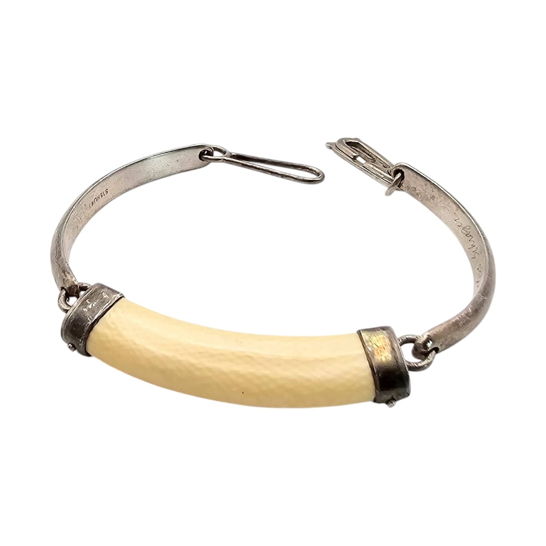 Native Southwestern Sterling Silver Bone Child’s Bracelet: A Native Southwestern child's bracelet crafted in sterling silver and featuring a bone centerpiece. Weighing 10 grams, this bracelet is adorned with metal end caps and a unique clasp mechanism. The in