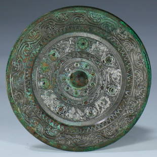 A Western Han Dynasty Bronze cast round mirror: A Western Han Dynasty (202 BC - 8 AD) Bronze cast round mirror, decorated with divine birds and beasts, with silver hot stamping on the protrusions.Provenance: I.K. Gallery AUS, a private collector in