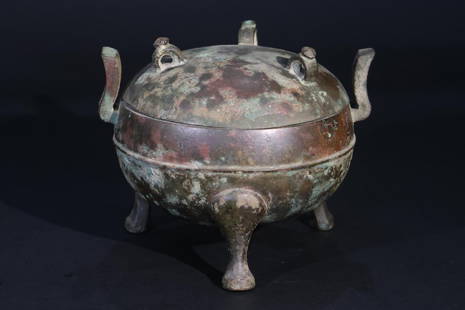 A covered bronze tripod: A covered bronze tripod, probably Han Dynasty, decorated with animal feet, animal buttons and cupped ear handles. One word inscription.