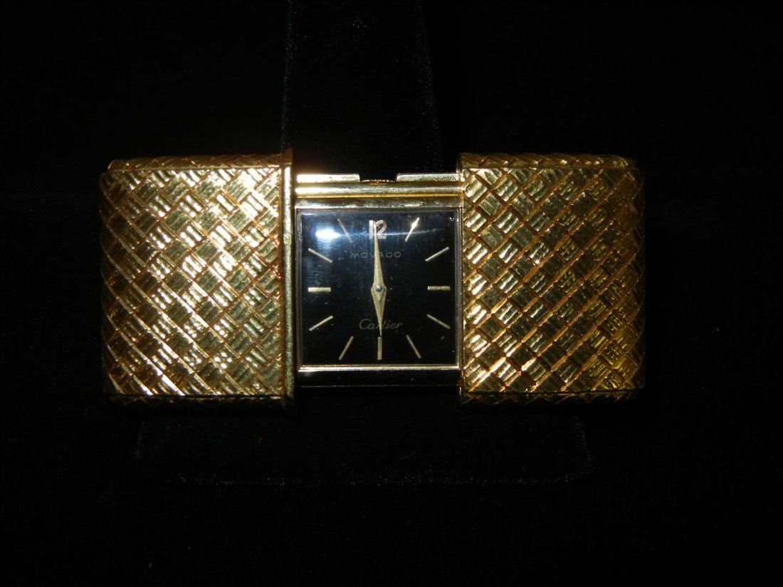 18KYG Cartier Travel Clock with Movado Movement: The basket weave motif case slides open to reveal a black rectangular dial, applied baton markers within a yellow gold case insribed, "F.W.H. from C.A. and H.A. - 1968." It is signed "Cartier" and "Mo