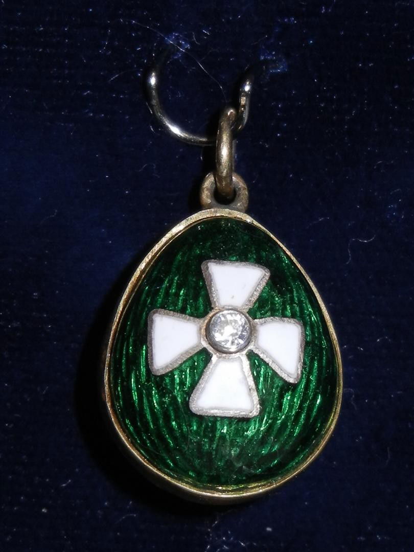 Russian Silver Enamel Egg With 84 Mark: A sterling emerald Russian silver egg charm with a white enameled St. George cross marked "84" silver(see photo). There is a small diamond in the center of the cross. The charm measures 3/4."