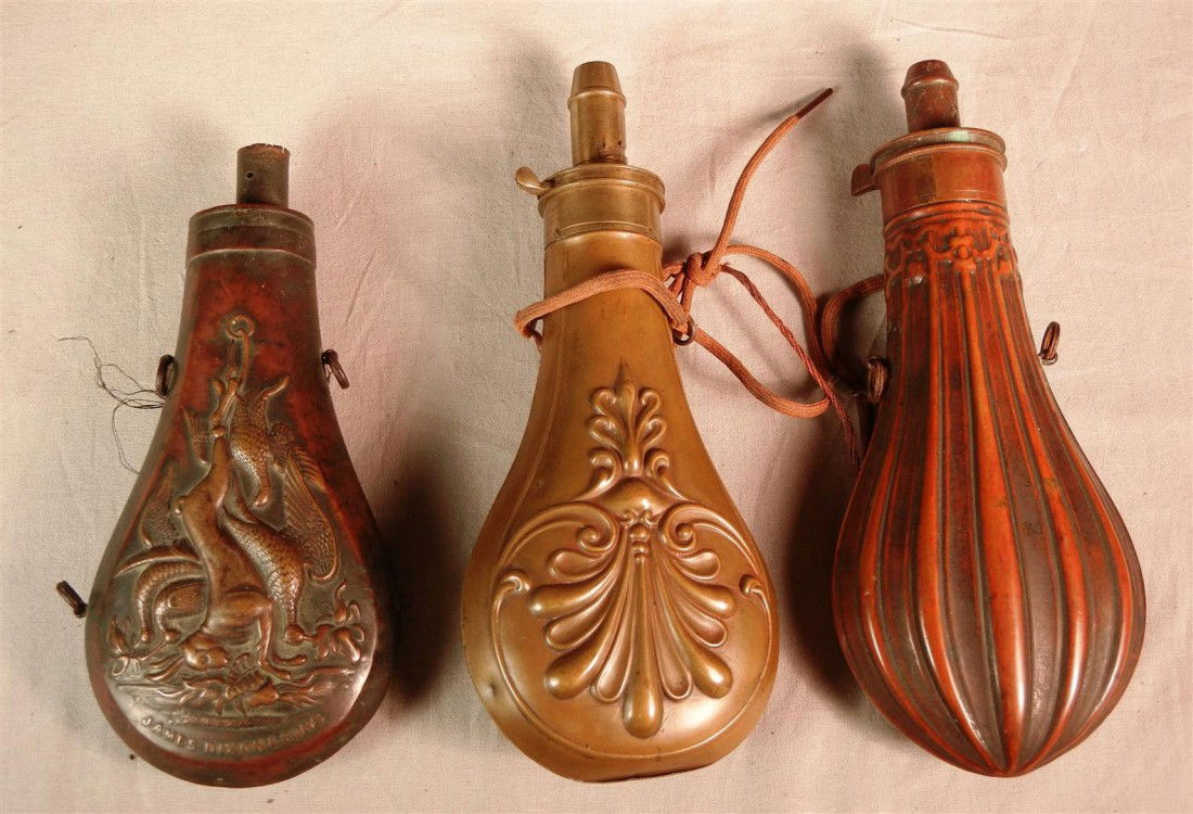 Lot of Three Rare Copper Powder Flasks: An 18th century copper powder flask made by James Dixon & Sons (marked on bottom). Powder flask has hanging game as central image and measures 7." The second flask is an 18th century American powder f