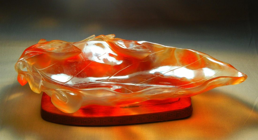Chinese Carved Carnelian Brush Washer: 19th century Chinese carved carnelian leaf shaped brush washer with fruit and branch motif on footed stand measuring 9 1/2"L x 5 H."