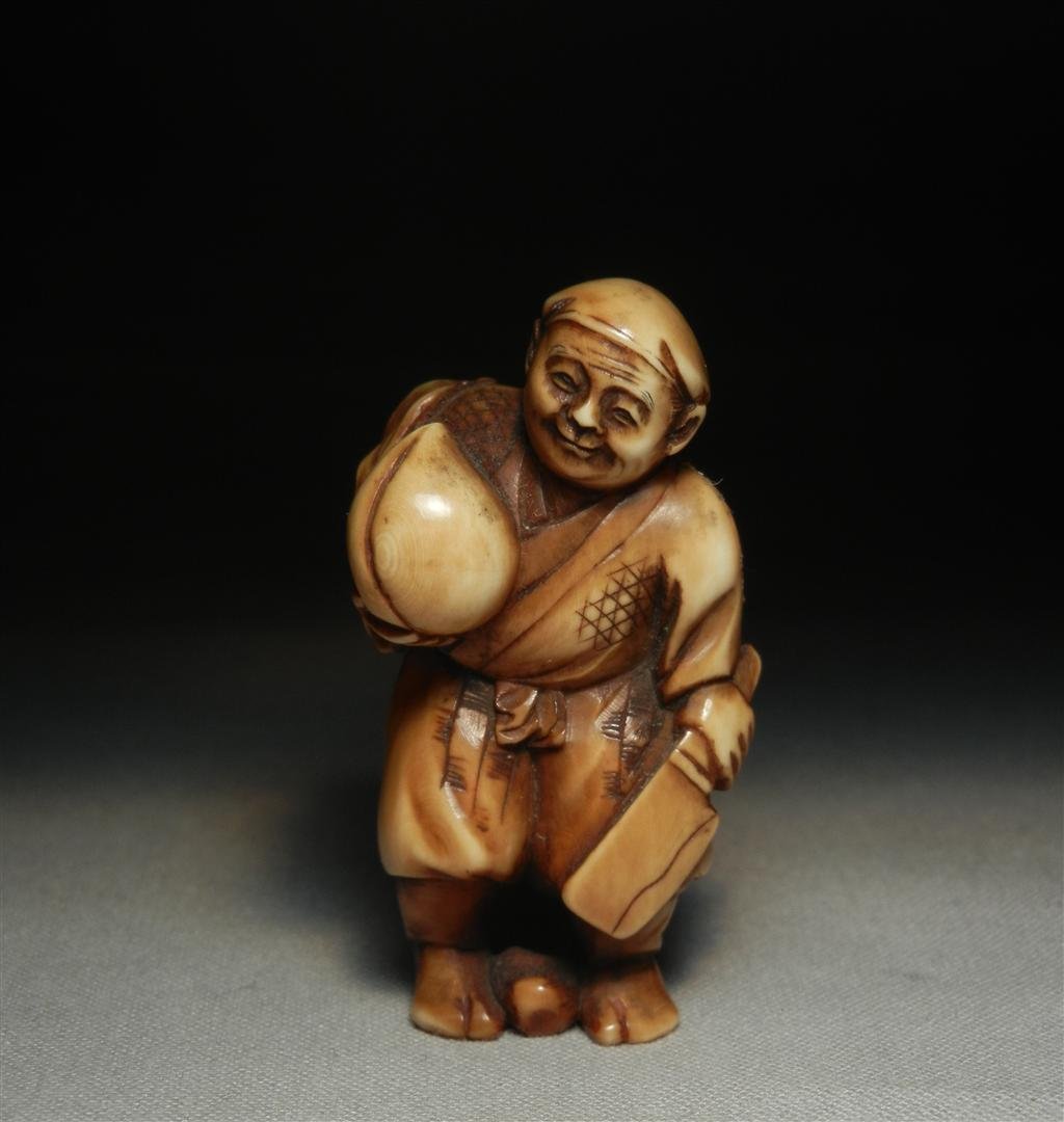 19thc. Ivory Netsuke: 19th century ivory netsuke of a man holding a cleaver measuring 2."