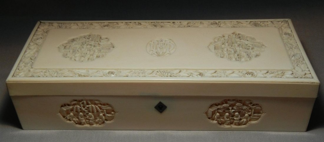 19thc. Carved Ivory Box: 19th century carved and reticulated ivory box with oriental genre scenes in cartouche with center monogram. Box measures 2 1/4" x 9 1/4" x 4."