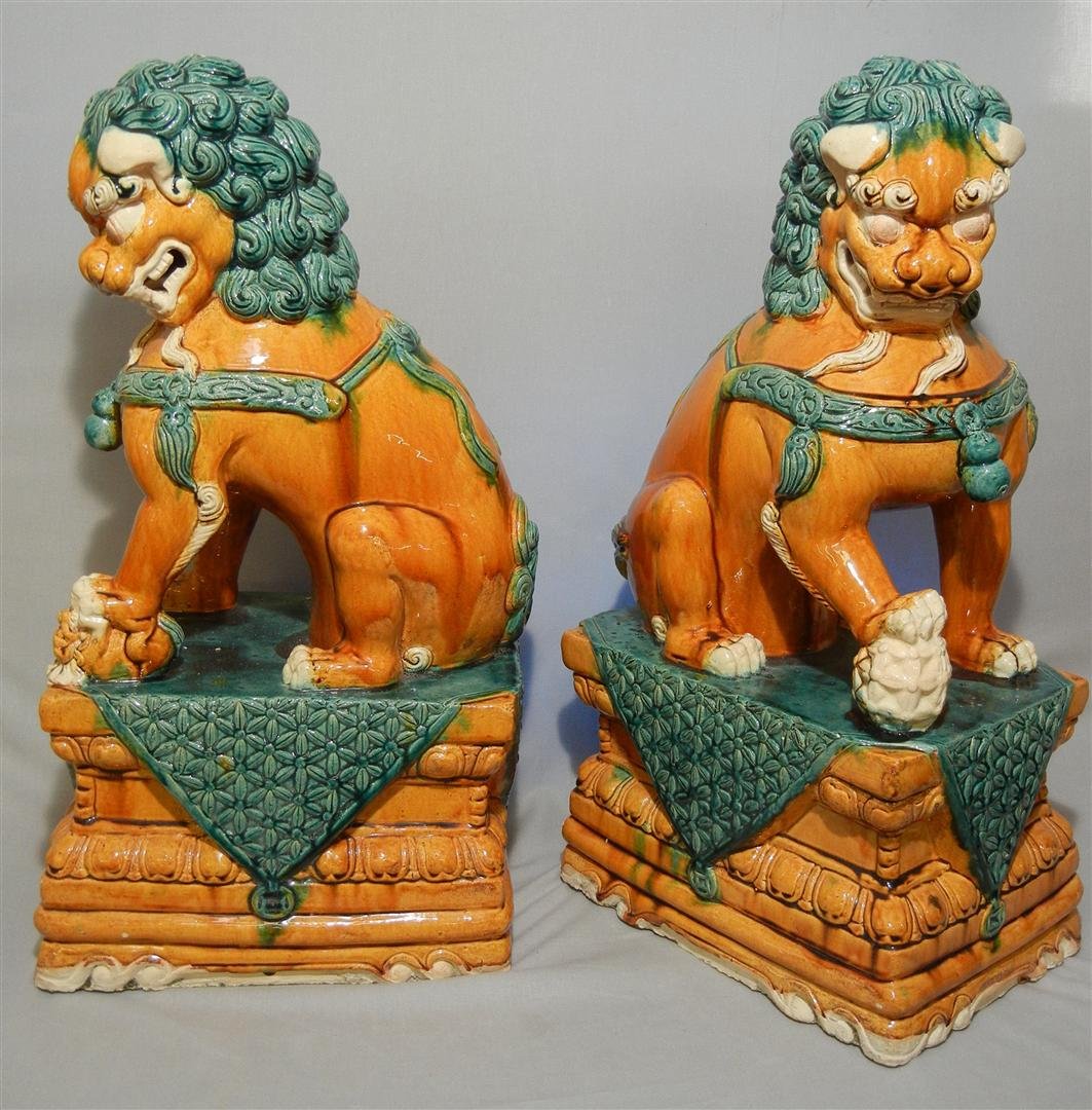 Pair Chinese Tang Style Foo Dogs: Pair of 20th century foo dogs with green and orange glaze, in the Tang style. Foo dogs measure 24 1/2" x 12 3/4" x 9."