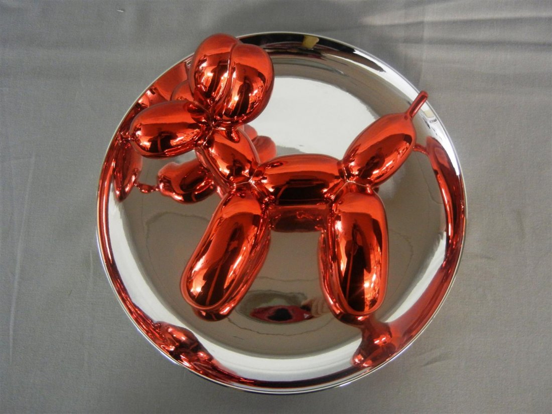Jeff Koons, "Balloon Dog": Red "Balloon Dog" porcelain object with reflecting and mirrored red glaze by American artist Jeff Koons (1955-). Three dimensional art piece measures 11 1/2" x 5." Label on verso has plate number (443