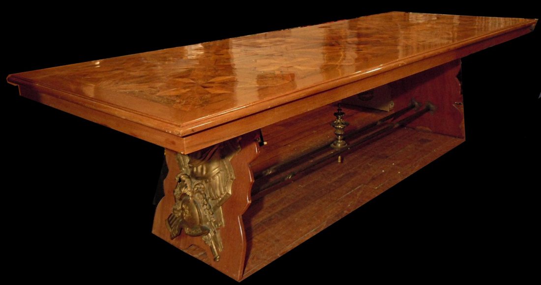 Custom French Dining Room Table: Custom French dining room table with high relief. Table has gladiator bronze mounts and a double bronze stretcher with finial and parquetry top. The table measures 9'6" x 3'8."