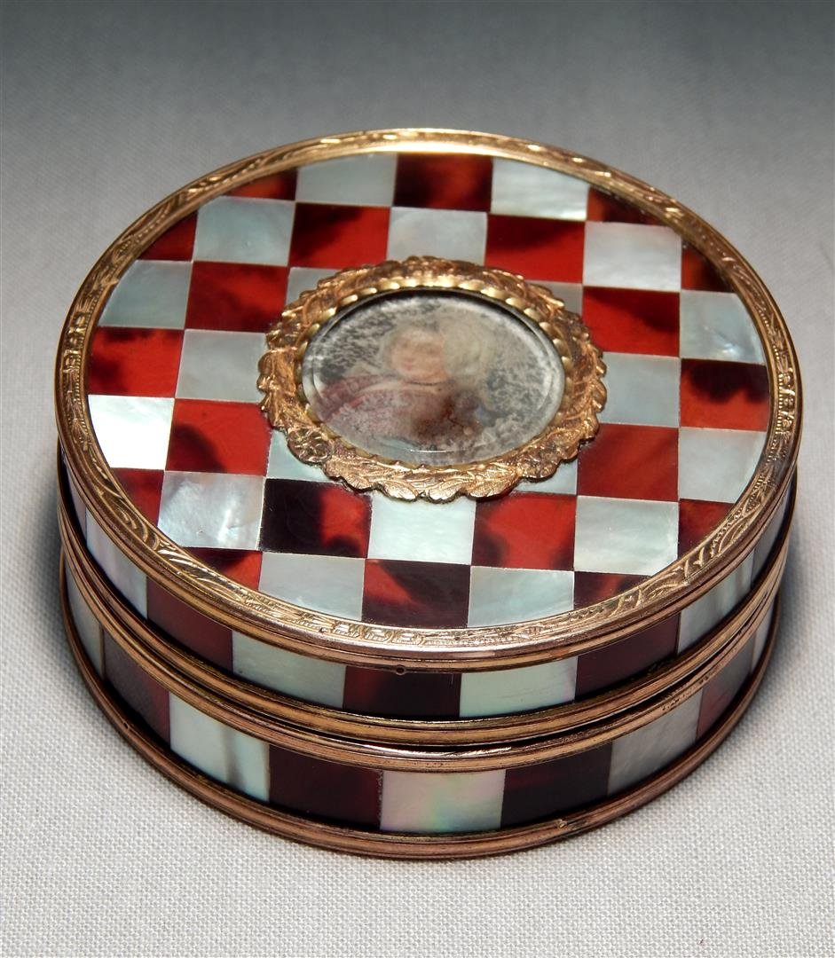 Mother of Pearl & Gold Metal Box: Checkered mother of pearl and gold metal box featuring a faded woman' s portrait in the center. The box measures 1" x 2 1/2."