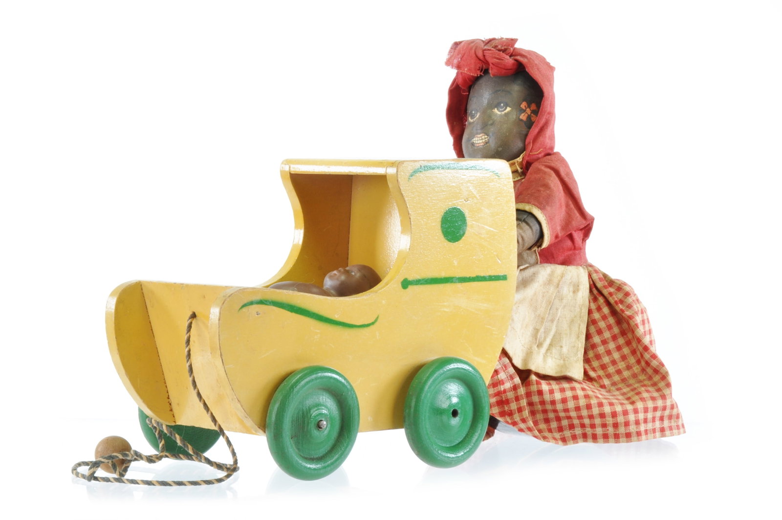 Black Americana Pull Toy Cloth Mammy Pushing Porcelain Black Baby in Wooden Baby Carriage: Black Americana pull toy featuring a cloth mammy pushing a porcelain Black baby in a wooden baby carriage. When pulled, the mammy's legs move with the carriage. The wooden carriage has a patent mark o