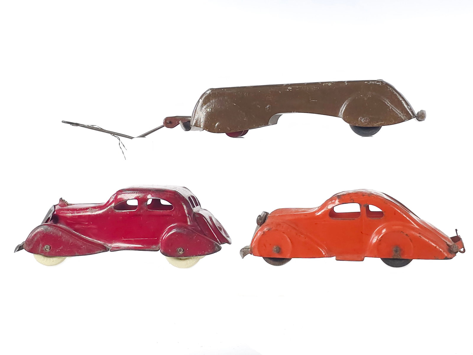 (3) Assorted Marx Steel Toys Including Airflow and Wagon: Three small scale steel toys in original paint. The lot includes a nicely streamlined brown wagon, an orange Airflow, and a red sedan with proper grilles. The largest toy measures approximately 7.5" L