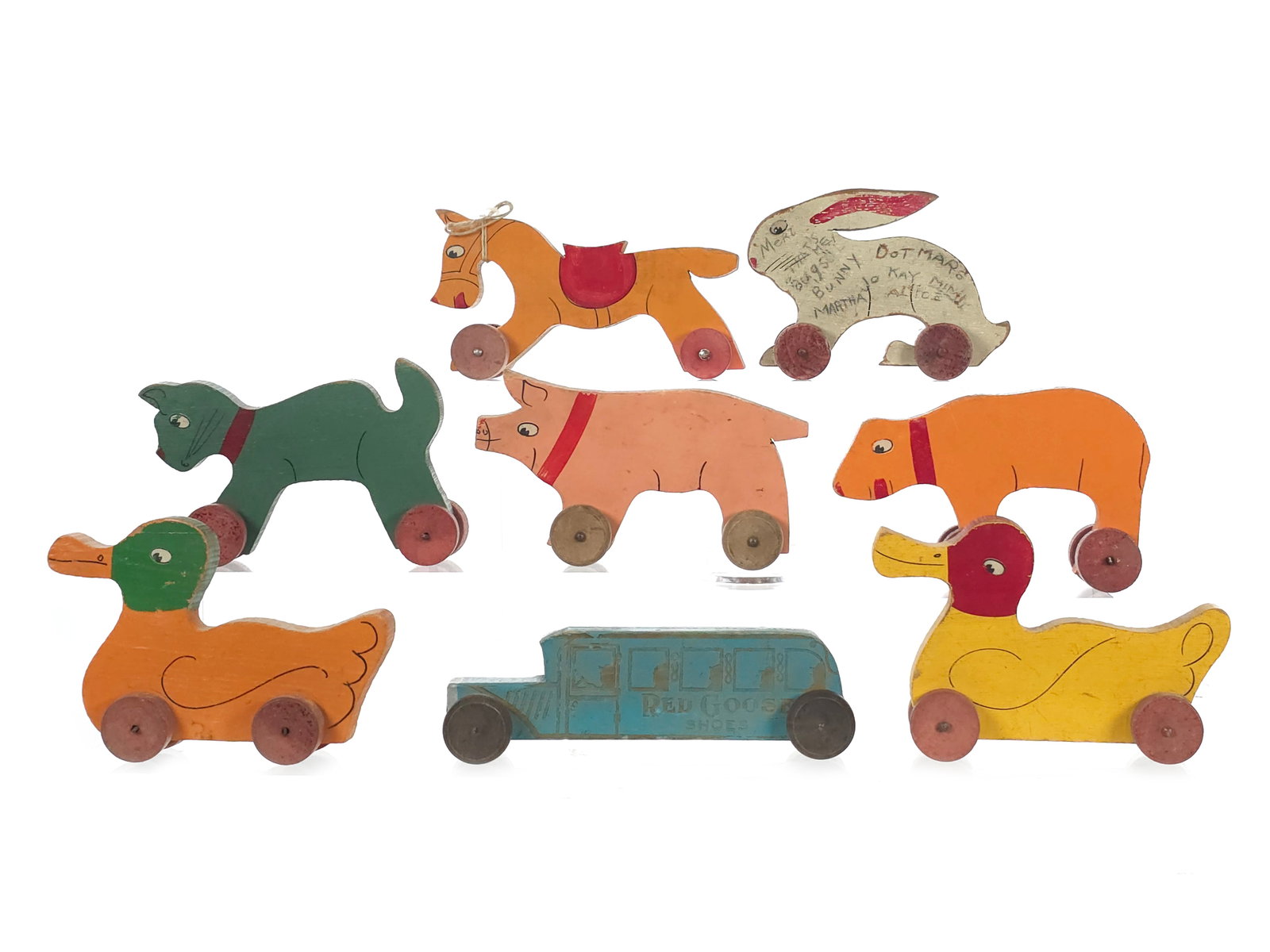 (8) Assorted 1930s Wooden Animal and Red Goose Shoes Bus Toys: Assorted 1930s wooden animal and bus toys with rolling wheels. The lot includes the sought-after Red Goose Shoes bus along with other carved and painted wooden examples. A charming grouping of early w