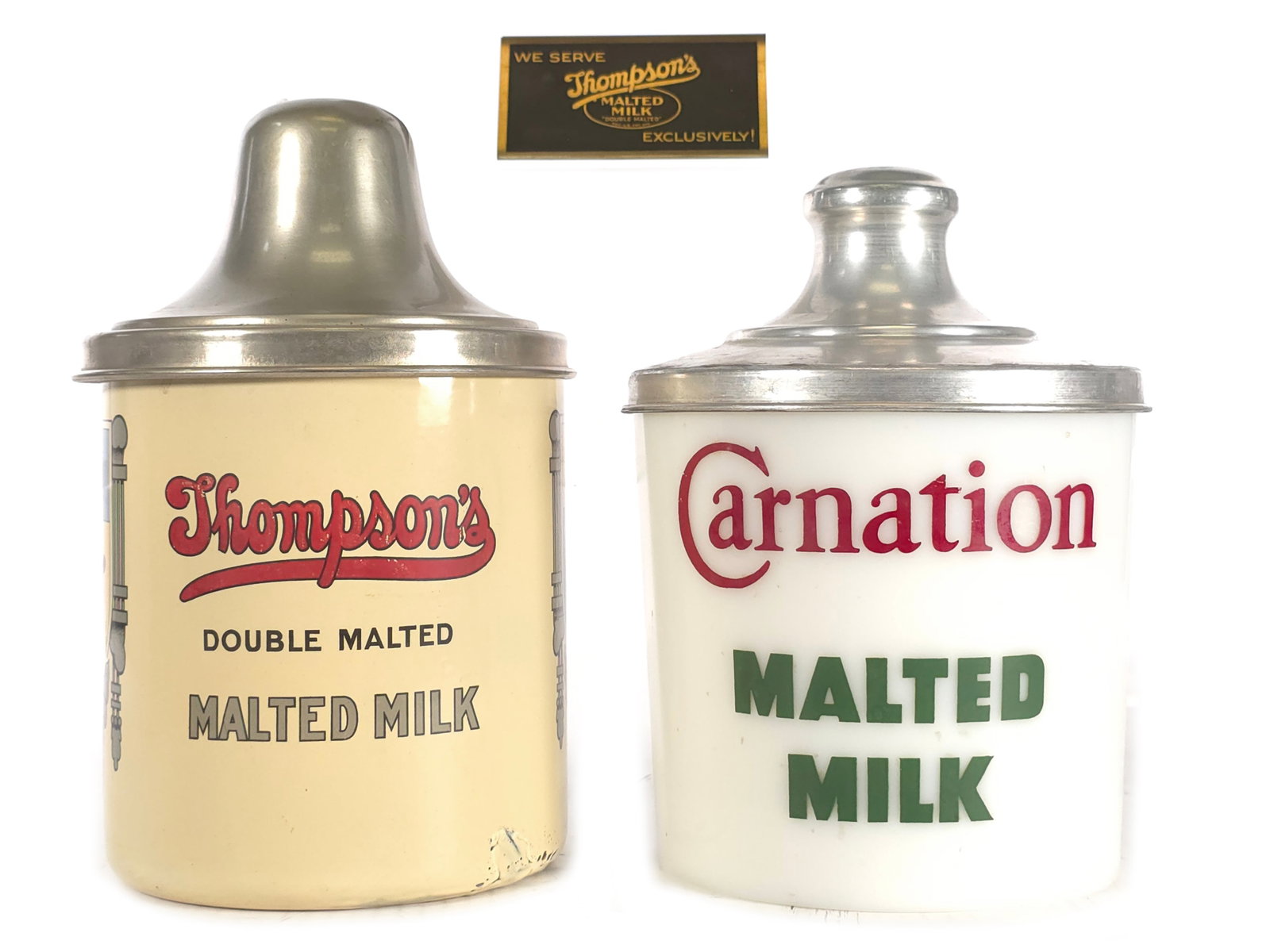 (2) Vintage Carnation & Thompson's Double Malted Milk Canisters: A pair of vintage malted milk canisters. Included is a 1940s/1950s Carnation Malted Milk canister with white glass body and metal lid measuring approximately 8.5" H x 6" D. Also included is a Thompson