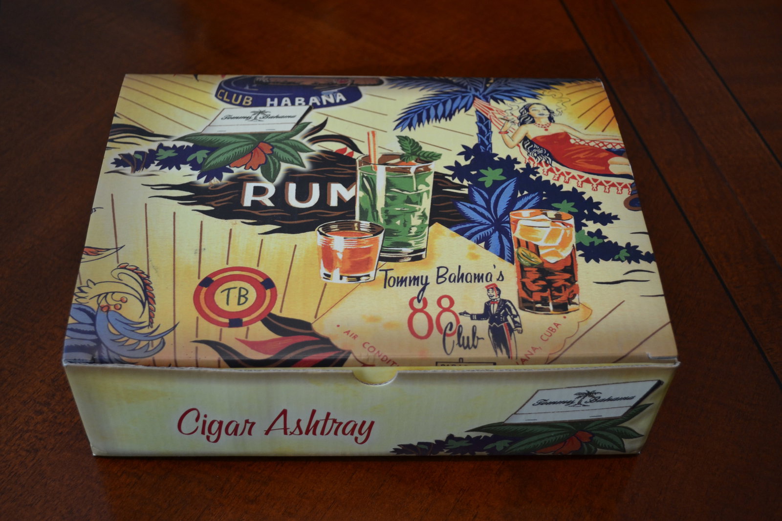 Vintage NIB Tommy Bahama Habana Cigar Ashtray: New Tommy Bahama's 88 Club Cigar Ashtray New in Box with matching package of Tommy Bahama Cocktail Napkins. Tommy Bahama's 88 Club Cigar Ashtray ~ Color is Multi - Black Sides & Bottom ~ Glazed Cerami