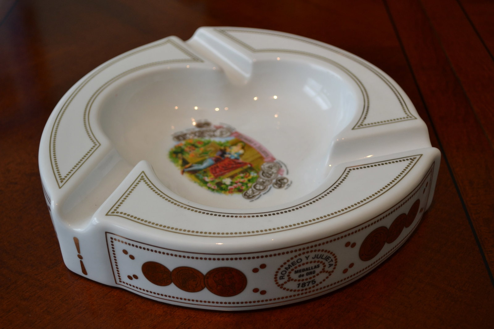 Romeo y Julieta Medallas de Oro 1875 Cigar Ashtray: Romeo y Julieta Medallas de Oro 1875 Cigar Ashtray 10" White/Gold Fine craftmanship and beautiful design. Measures 10" diameter by 2" height with three cigar holders. In excellent condition. No origin