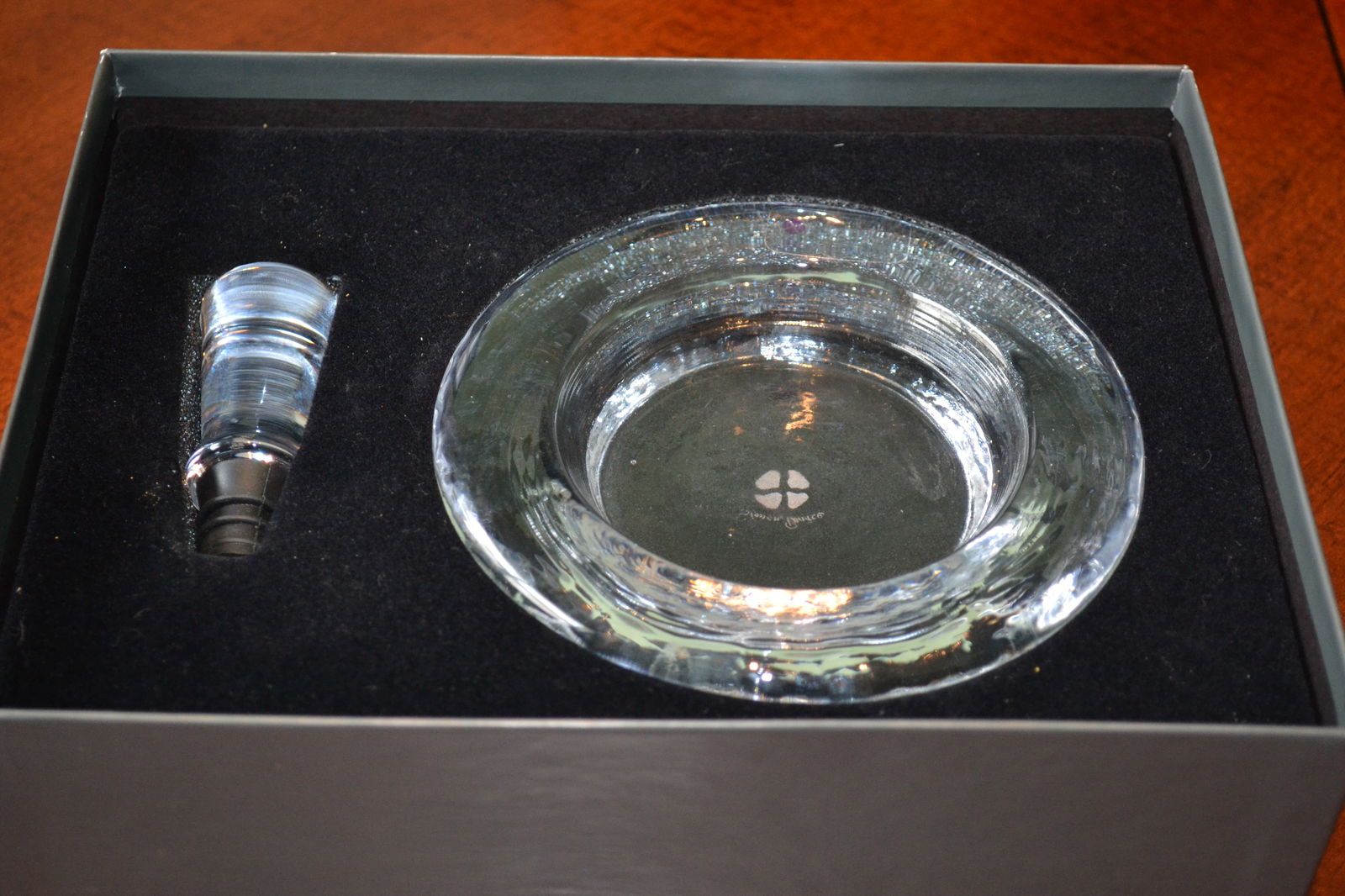 Simon Pearce Wine Coaster & Stopper Set NIB: Crystal clear Hanover Wine Coaster & Stopper Set New in Box adds sparkling simplicity to your table, protecting surfaces from the dew of a chilled white. Doubles as a snack-size candy/nut dish, or an