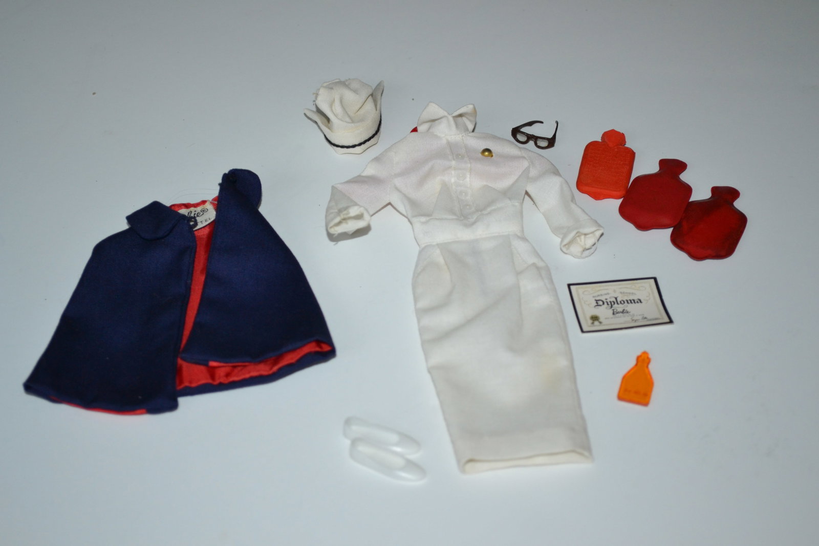 Mattel Barbie Registered Nurse 0991 Outfit 1960's: Mattel Barbie Registered Nurse 0991 Outfit 1960's trim white cotton uniform with zipper back, buttoned blouse and real hip pockets. With her spectacles and graduate nurse's cap, she wears a navy-blue 