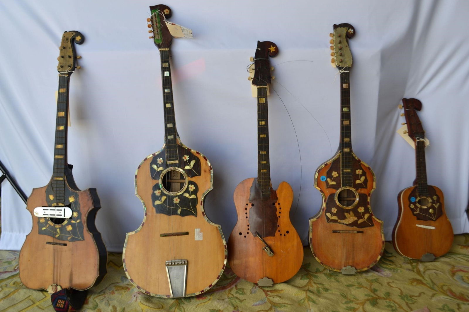 MUSICAL STRINGED GUITAR SET OF 5 MIXED SIZES: MUSICAL STRINGED GUITAR SET OF 5 MIXED SIZES Created from carved wood and decorative inlay. Iconic neck and body styles. Great Condition. Unknown Maker Provenance Slotin Folk Art Gallery Georgia