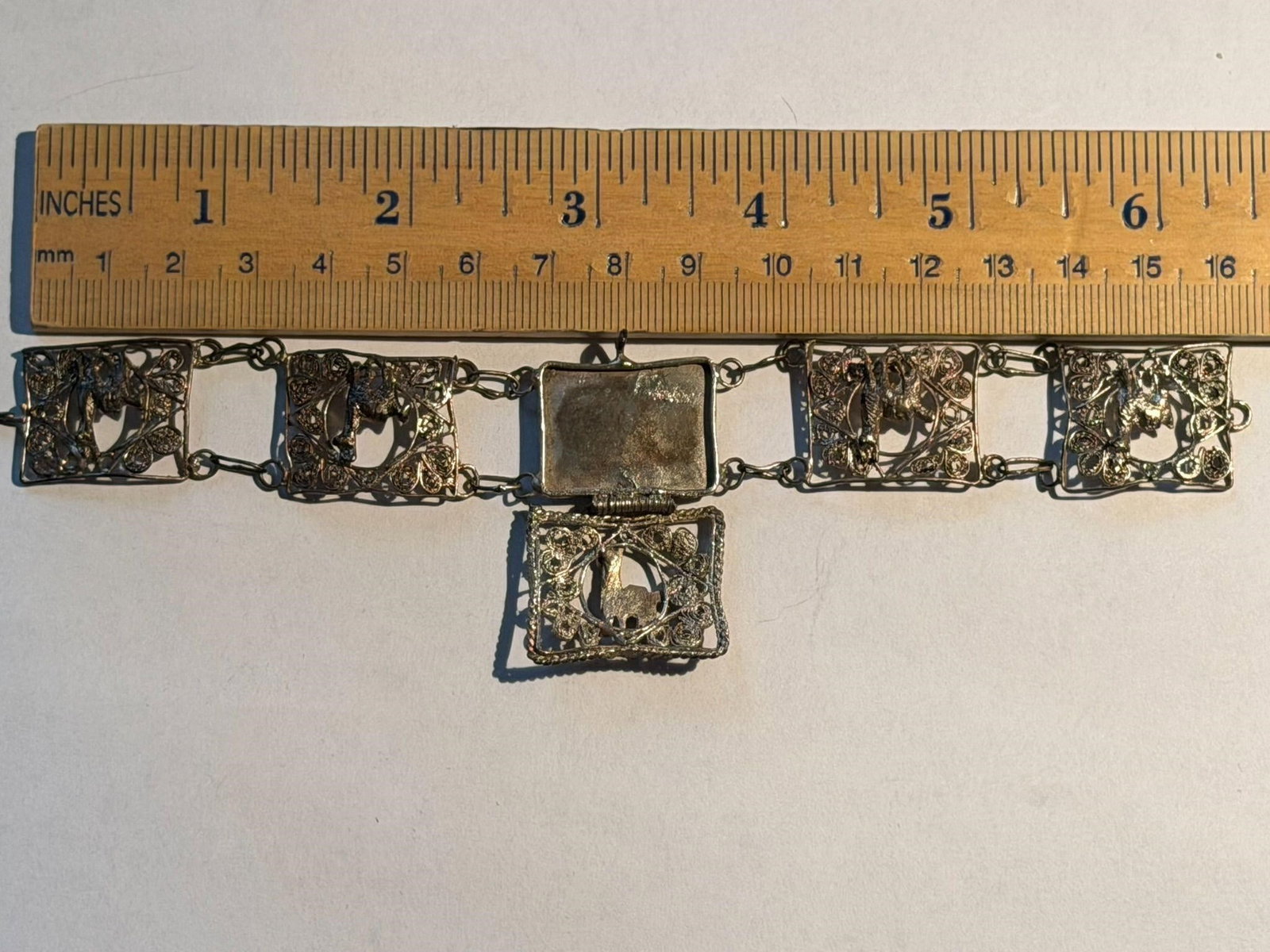 Vintage Peruvian Filagree Bracelet Sterling Silver: Vintage Peruvian Filagree Bracelet Sterling Silver filigree panel bracelet depicting llama or alpaca design, likely dating from the 1920s to 1930s. Center panel opens like a locket.Measures 6.5" Lengt