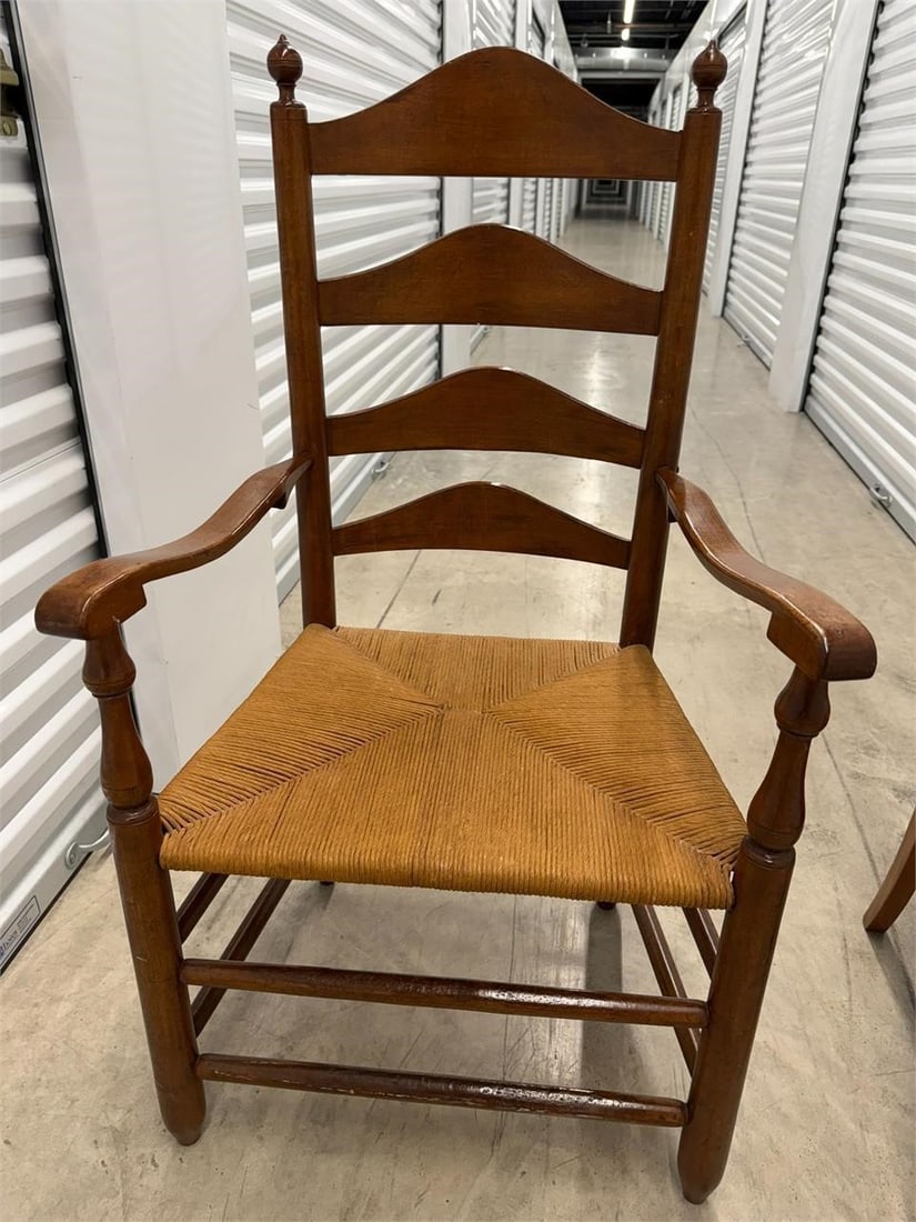 Ladderback Armchair with a Woven Rush Seat: Vintage American-style ladderback armchair with a woven rush seat, commonly found in colonial or farmhouse styles. Measures 22"W x 20"D x 42"H
