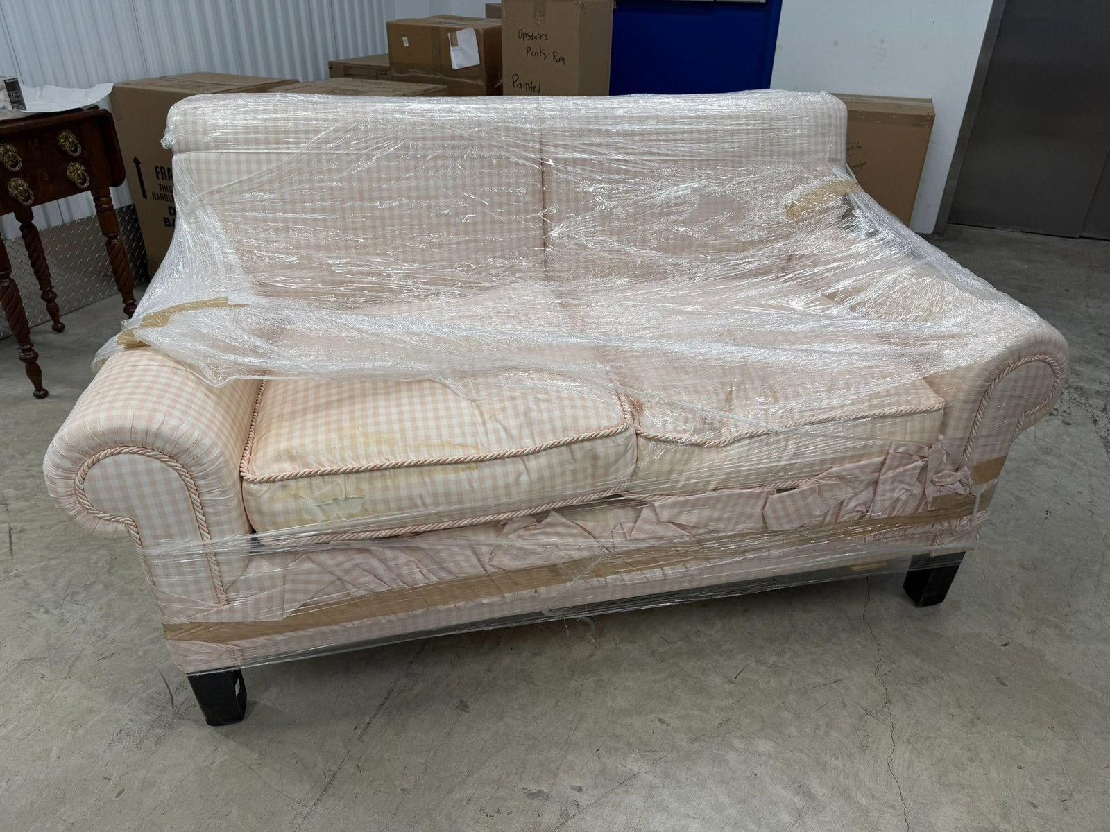 Loveseat Upholstered Gingham Check Fabric: Traditional Loveseat Upholstered in a white and beige gingham check fabric, featuring rolled arms and pleated skirting. Components for TVNote Cushion Fabric Damaged Measurements 54"L x 33"D x 34"H Sea