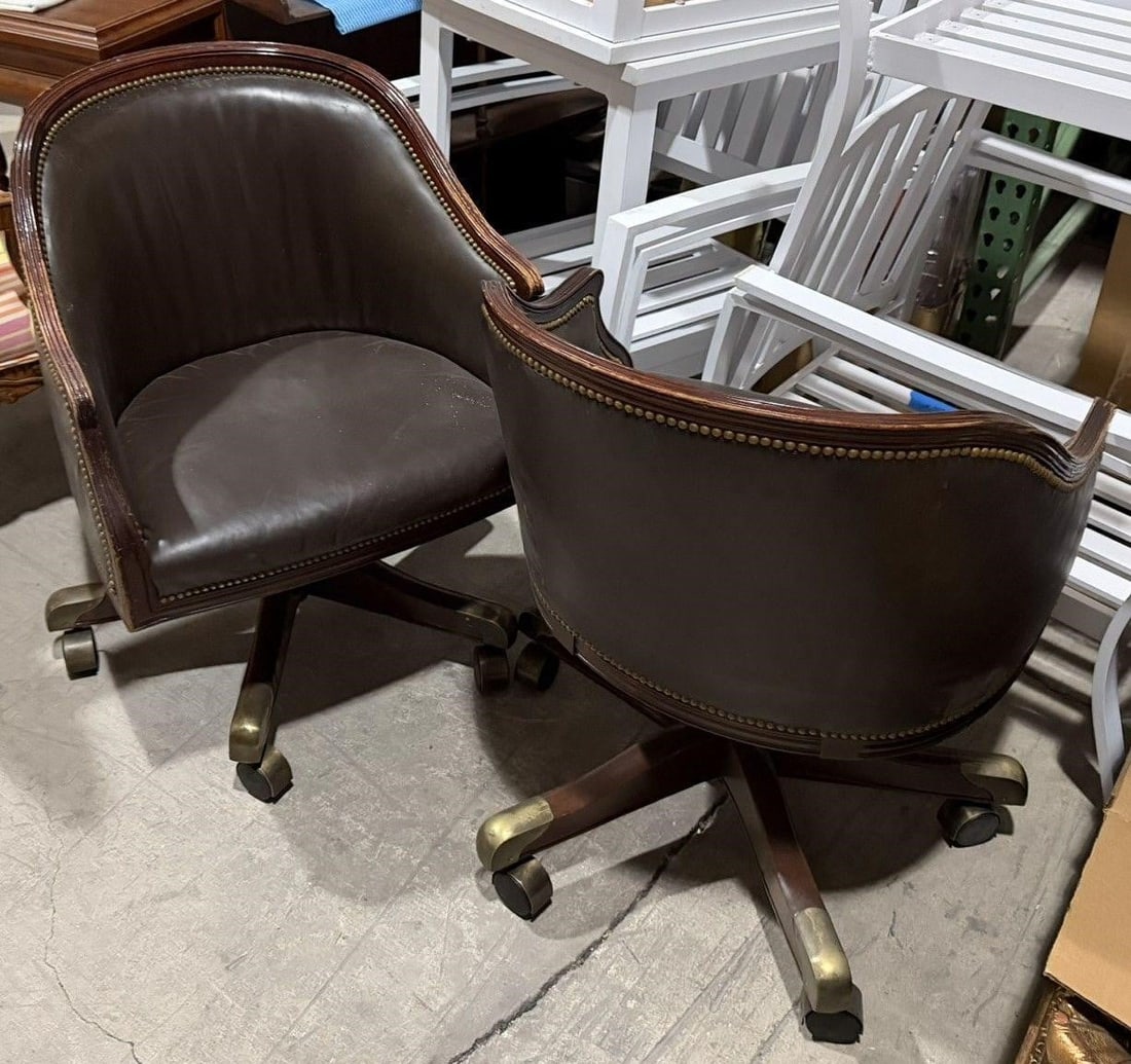 VINTAGE PAIR BROWN LEATHER BARREL SWIVEL CHAIRS: Vintage Pair brown leather barrel-back swivel captain's chairs featuring brass nail head trim and wooden bases on casters