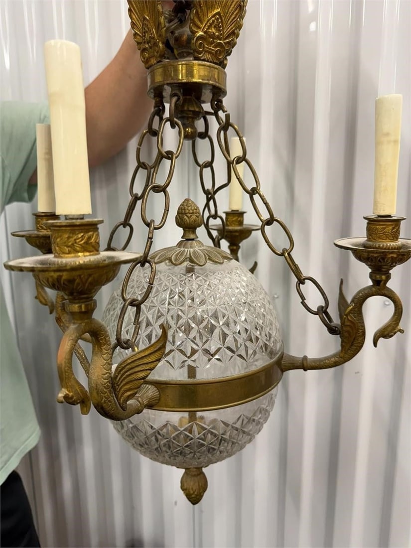 Vintage French Empire Style Chandelier Swan Arms: Vintage French Empire style chandelier featuring a central cut crystal glass ball and brass fixtures. Neoclassical French Empire style with swan-shaped arms. Structured around a central faceted crysta