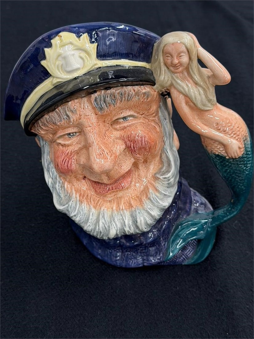 Royal Doulton Old Salt Skipper Mermaid Mug: Royal Doulton "Old Salt" Character Jug, Model D6551 Artist: Gary SharpeFeatures a fisherman in a blue sailor's cap and jersey with a mermaid forming the handle. Issued between 1961 and 2001.Measures 7