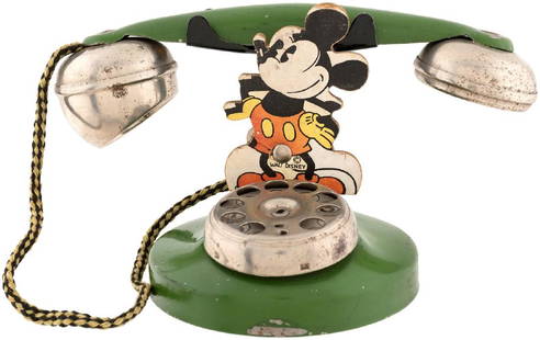 MICKEY MOUSE N.N. HILL TOY TELEPHONE.: 7.5" tall painted pressed steel toy telephone w/3" tall thick die-cut cardboard Mickey Mouse figure attachment. N.N. Hill Brass Co. c. 1934. N.N. Hill produced a number of different Disney telephone t