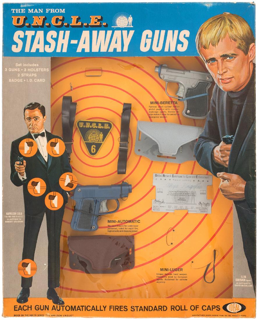"THE MAN FROM U.N.C.L.E. STASH-AWAY GUNS" BOXED IDEAL S: 16x20x2" deep window display box contains cap guns/holsters and comes w/"U.N.C.L.E. 6" plastic badge and 2.5x4" "United Network Command For Law And Enforcement" membership card (w/inked name). Box has