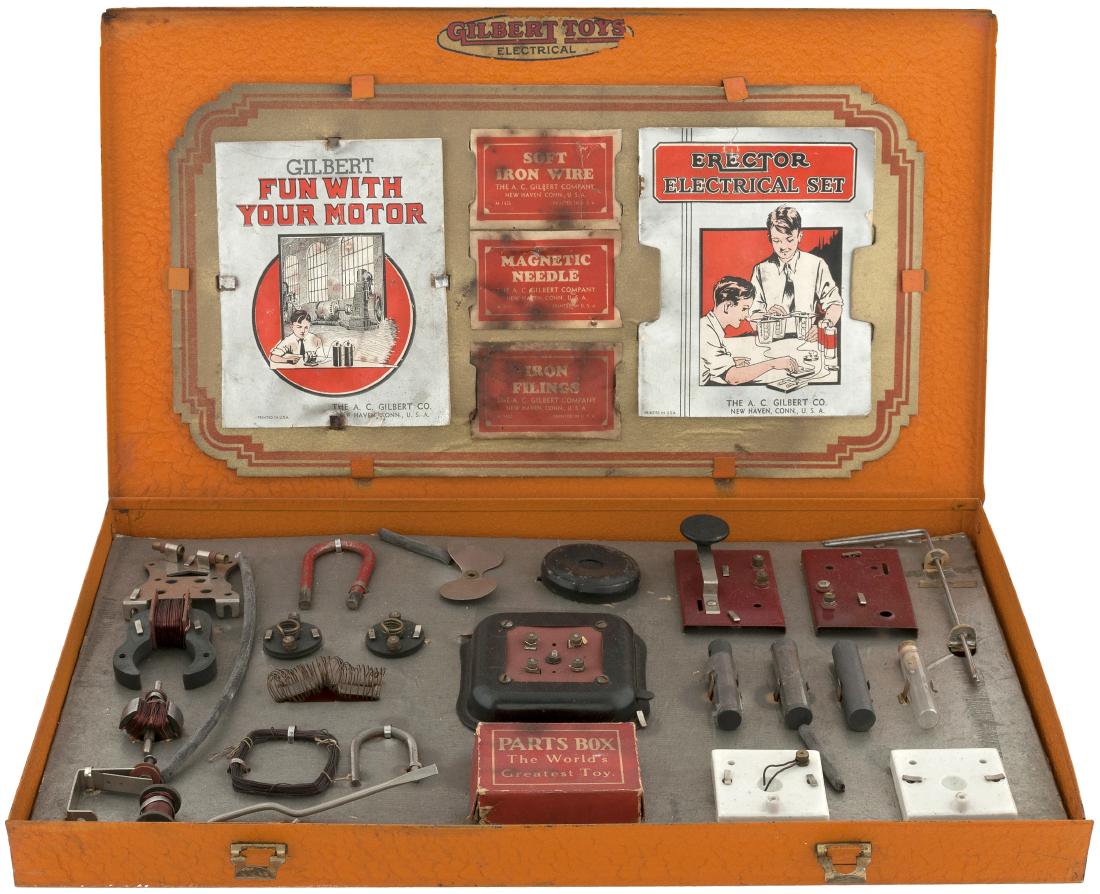 GILBERT "THE NEW ERECTOR ELECTRICAL SET" BOXED 1932 SET: 14.25x24.25x2" deep painted (textured orange) metal case contains A.C. Gilbert Co. set No. 5, 1932. Lid has metal fasteners and features illustrated decal featuring "The New Erector Electrical Set" te